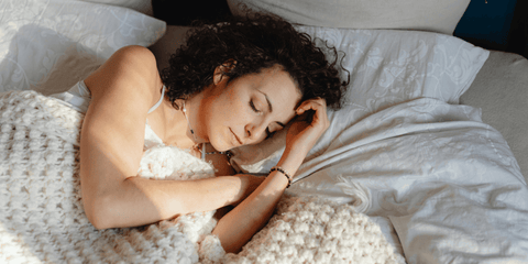 A Caucasian woman sleeping sideways on a bed